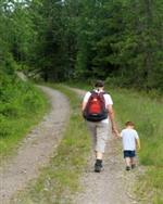 Mann og liten gutt lang skogssti - Klikk for stort bilde